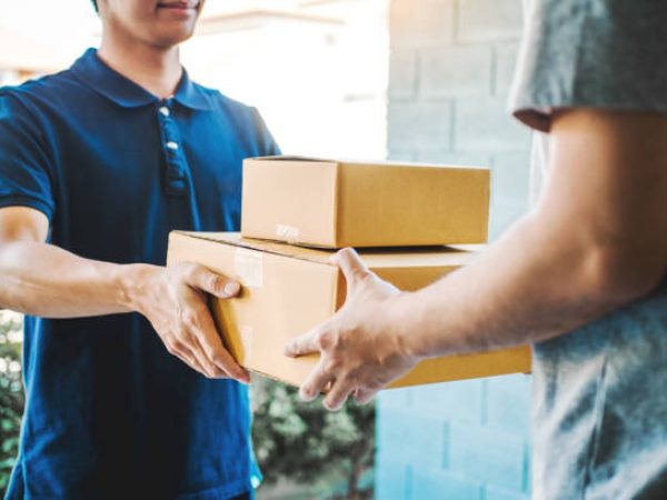 Delivery concept Asian Man hand accepting a delivery boxes from professional deliveryman at home